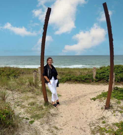 Manuela2 Gesichter von König Immobilien: Manuela Ott angelehnt an einem Stab mit Blick auf das Wasser