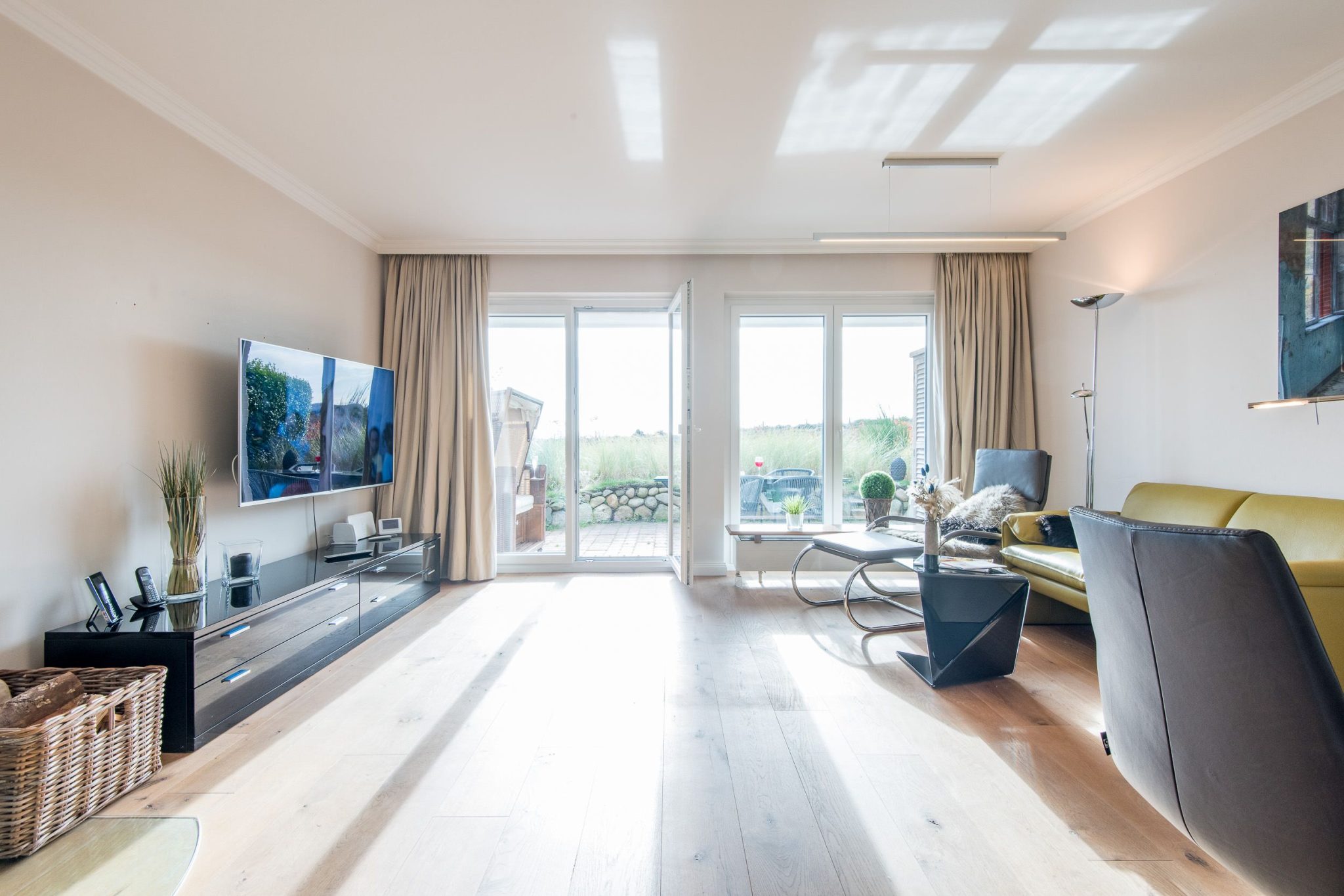 Wohnzimmer mit Fernseher und Sofa in Ferienhaus auf Sylt