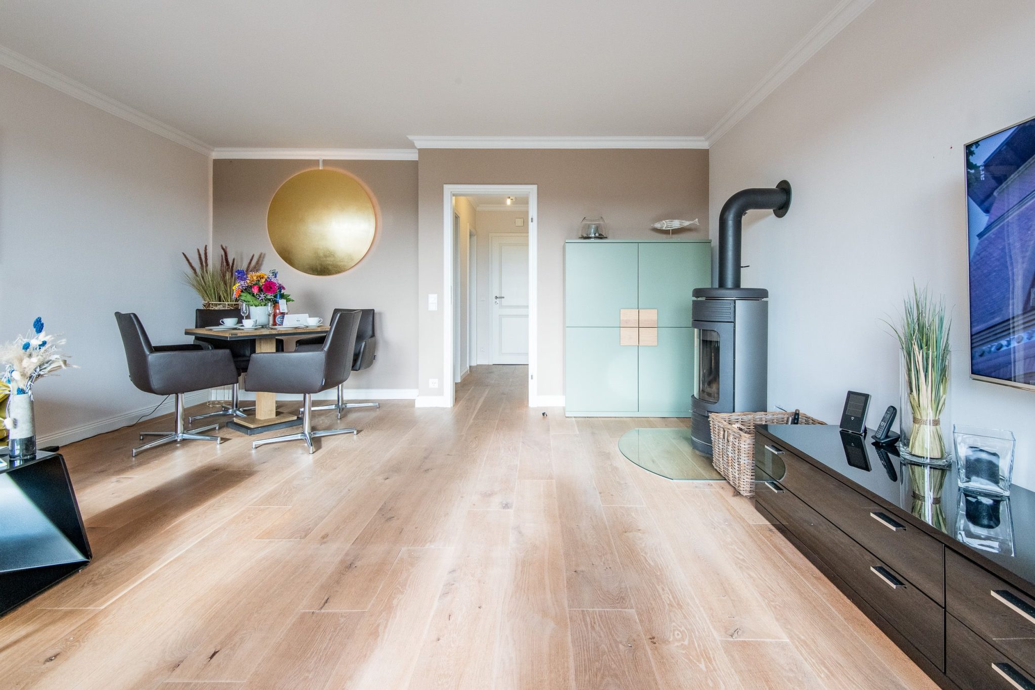 Wohnzimmer mit Kamin und Fernseher und Esstisch in Ferienhaus auf Sylt