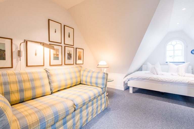 Schlafzimmer mit Doppelbett und Sofa in Ferienhaus auf Sylt