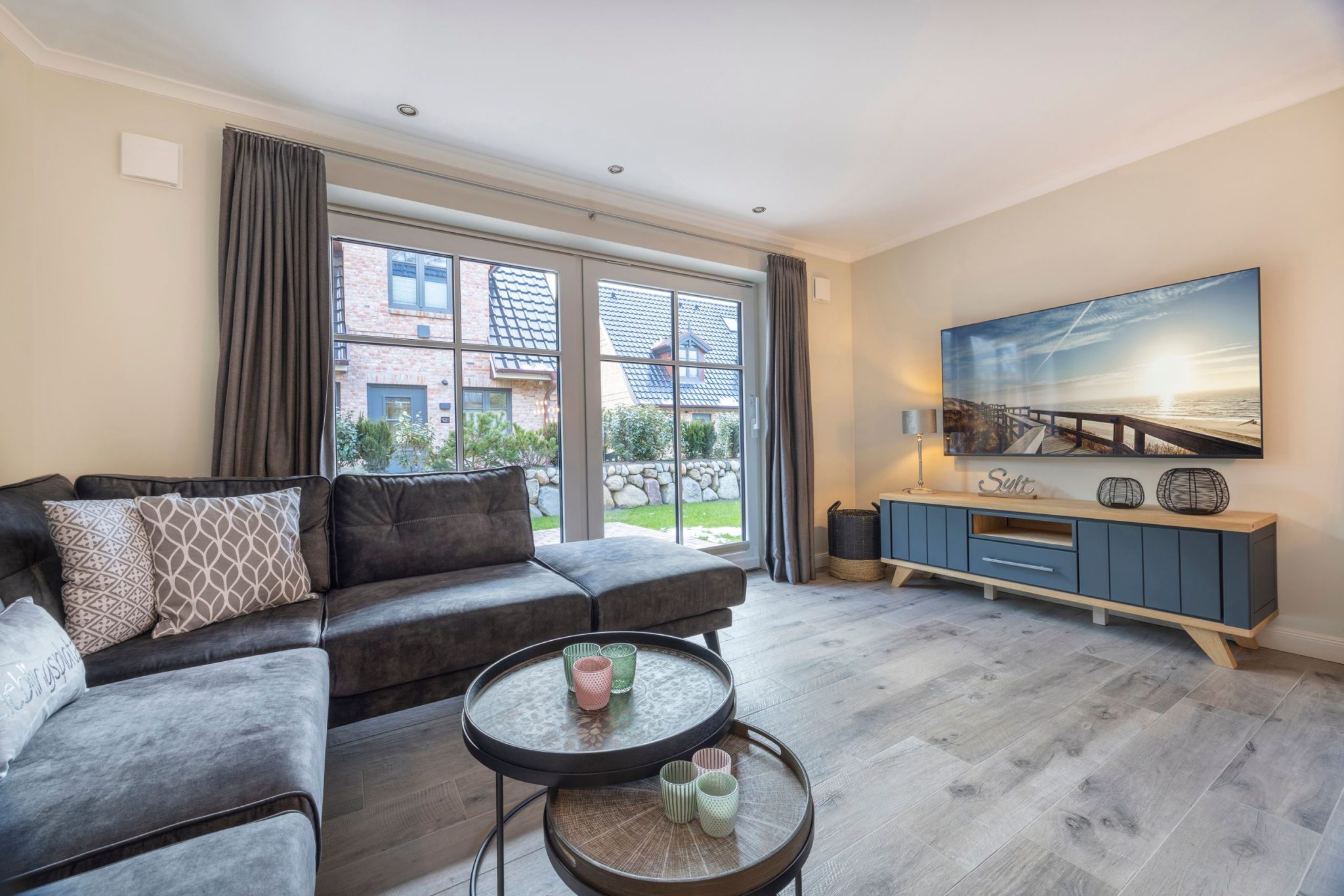 Wohnzimmer mit Fernseher und Sofa in Ferienhaus auf Sylt