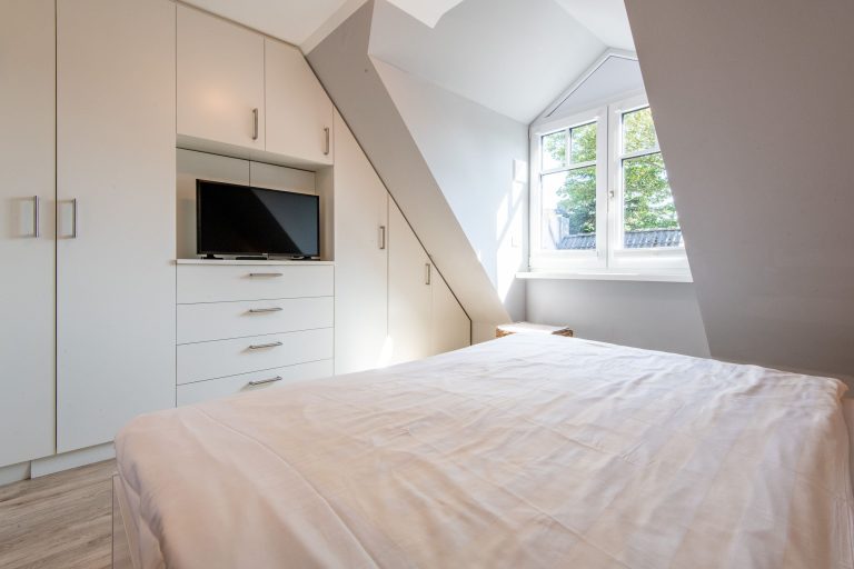 Doppelbett in Schlafzimmer mit Fernseher in Ferienhaus auf Sylt