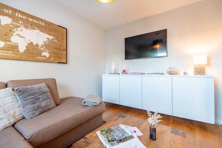 Wohnzimmer mit Sofa und Fernseher in Ferienhaus auf Sylt