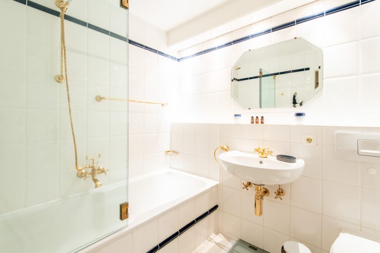 Badezimmer in weiß und Gold in Ferienhaus auf Sylt