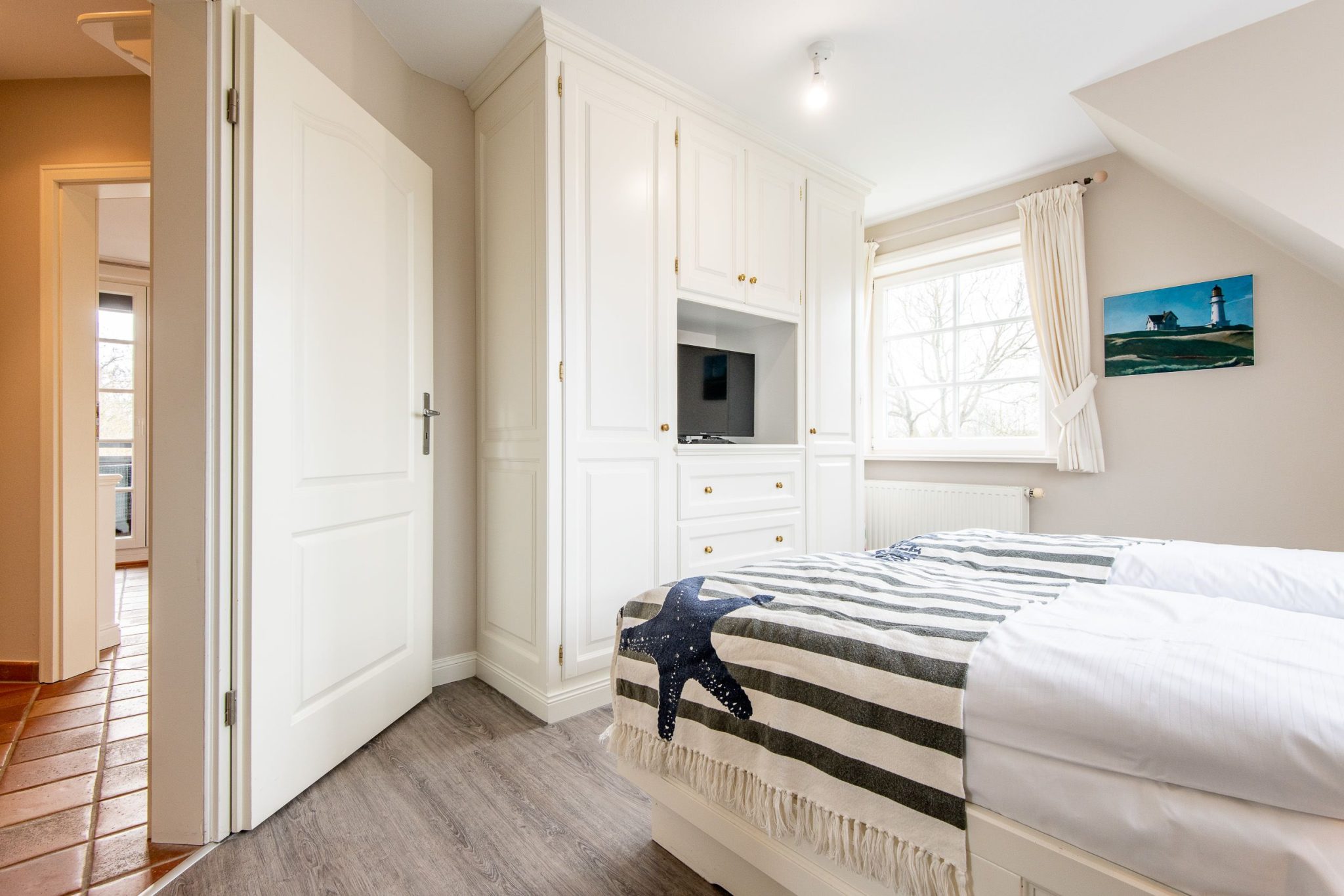 Schlafzimmer mit Doppelbett und Fernseher in Ferienhaus auf Sylt