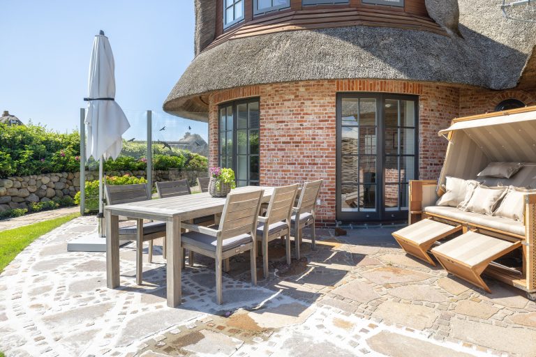 Terrasse mit Strandkorb und Gartenmöbel in Ferienhaus auf Sylt