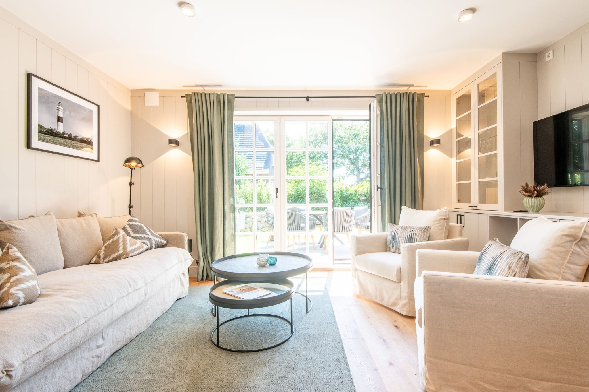 Wohnzimmer mit Sofa und Sessel in Ferienhaus auf Sylt