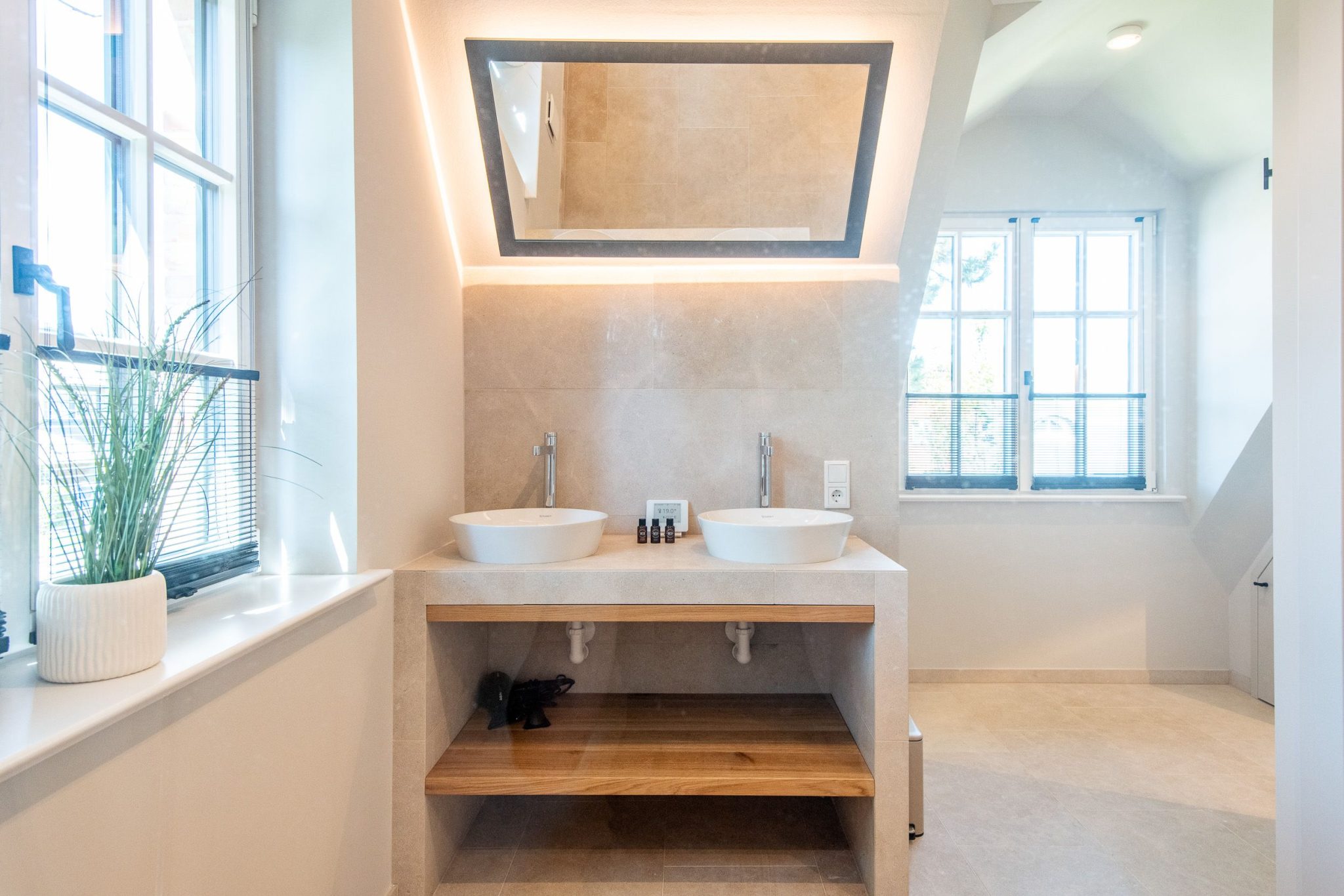 Badezimmer mit Waschbecken und Spiegel in Ferienhaus auf Sylt
