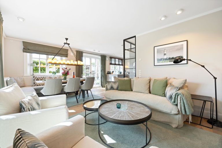 Wohnzimmer mit Sofa und Essbereich in Ferienhaus auf Sylt