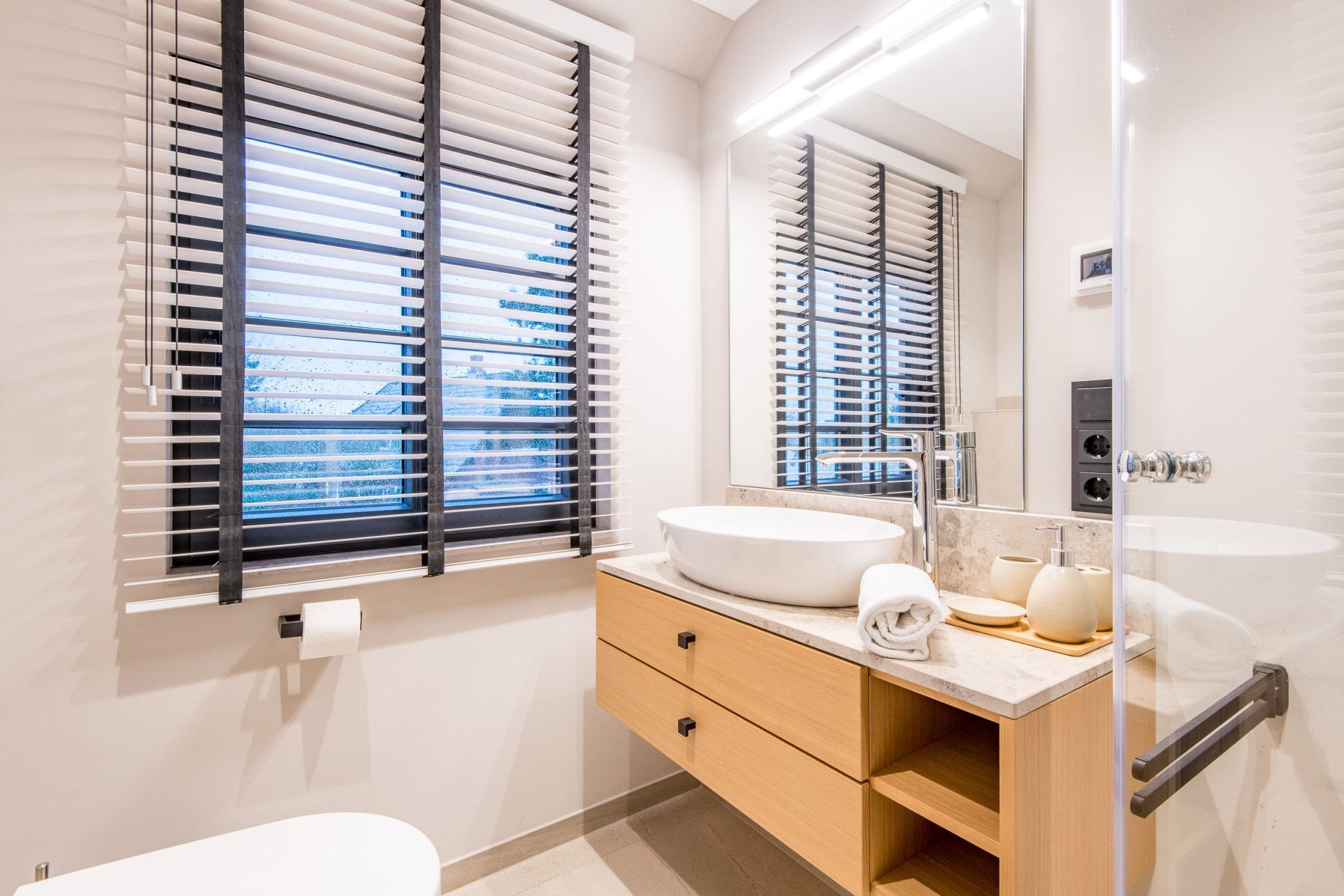 Badezimmer mit Spiegel und Dusche in Ferienhaus auf Sylt
