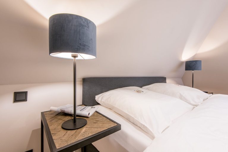 Schlafzimmer mit Doppelbett und Nachttischlampe in Ferienhaus auf Sylt