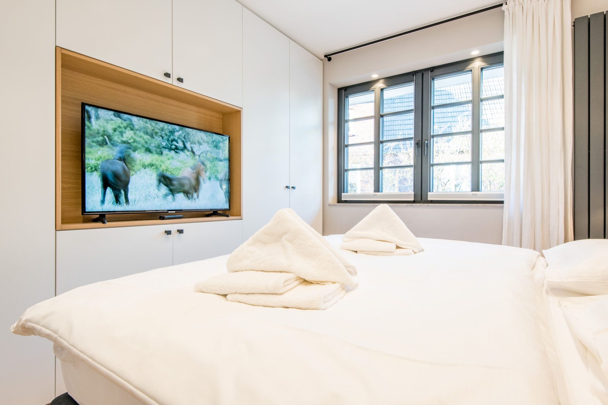 Schlafzimmer mit Fernseher und Doppelbett in Ferienhaus auf Sylt