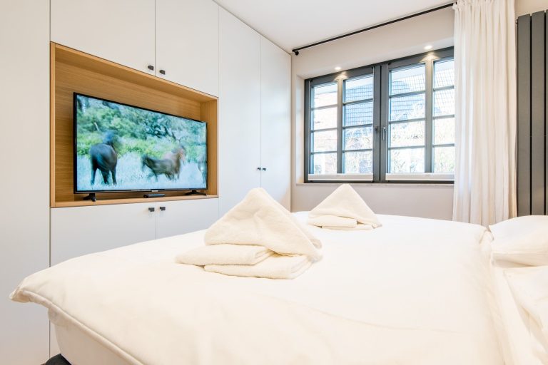 Schlafzimmer mit Fernseher und Doppelbett in Ferienhaus auf Sylt
