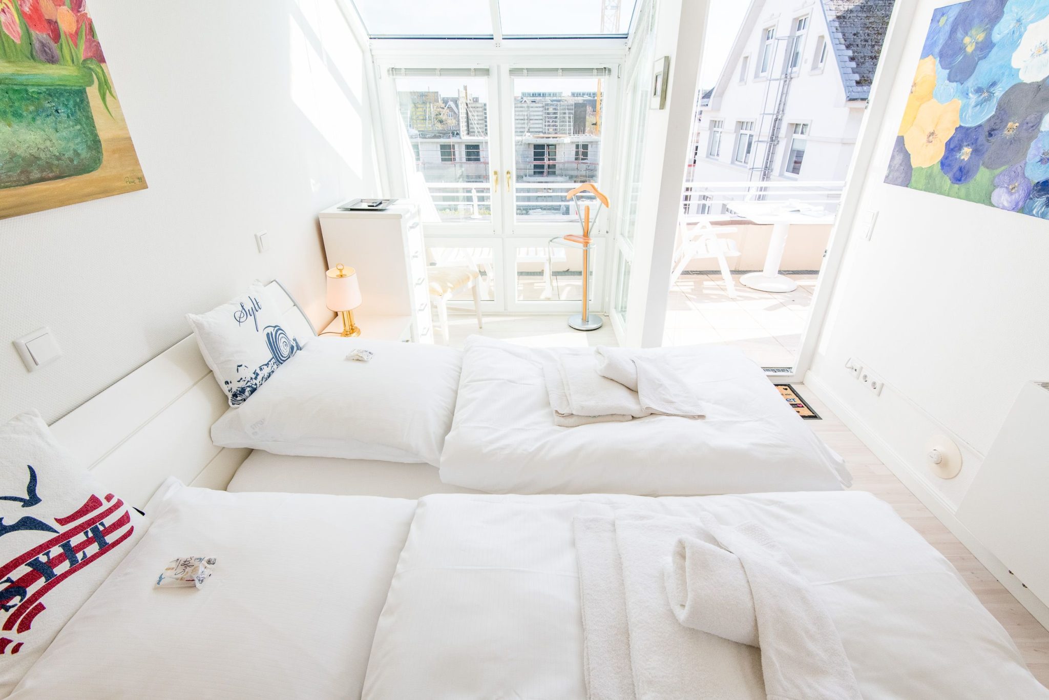 Doppelbett in Schlafzimmer mit Balkon in Ferienwohnung auf Sylt