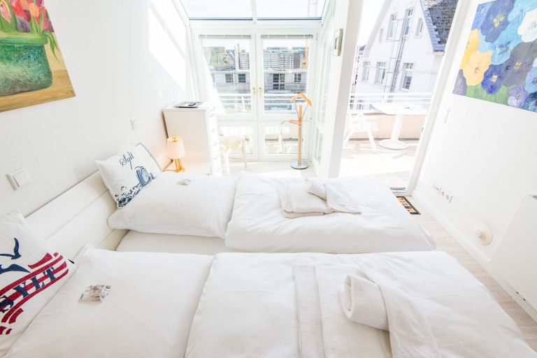Doppelbett in Schlafzimmer mit Balkon in Ferienwohnung auf Sylt