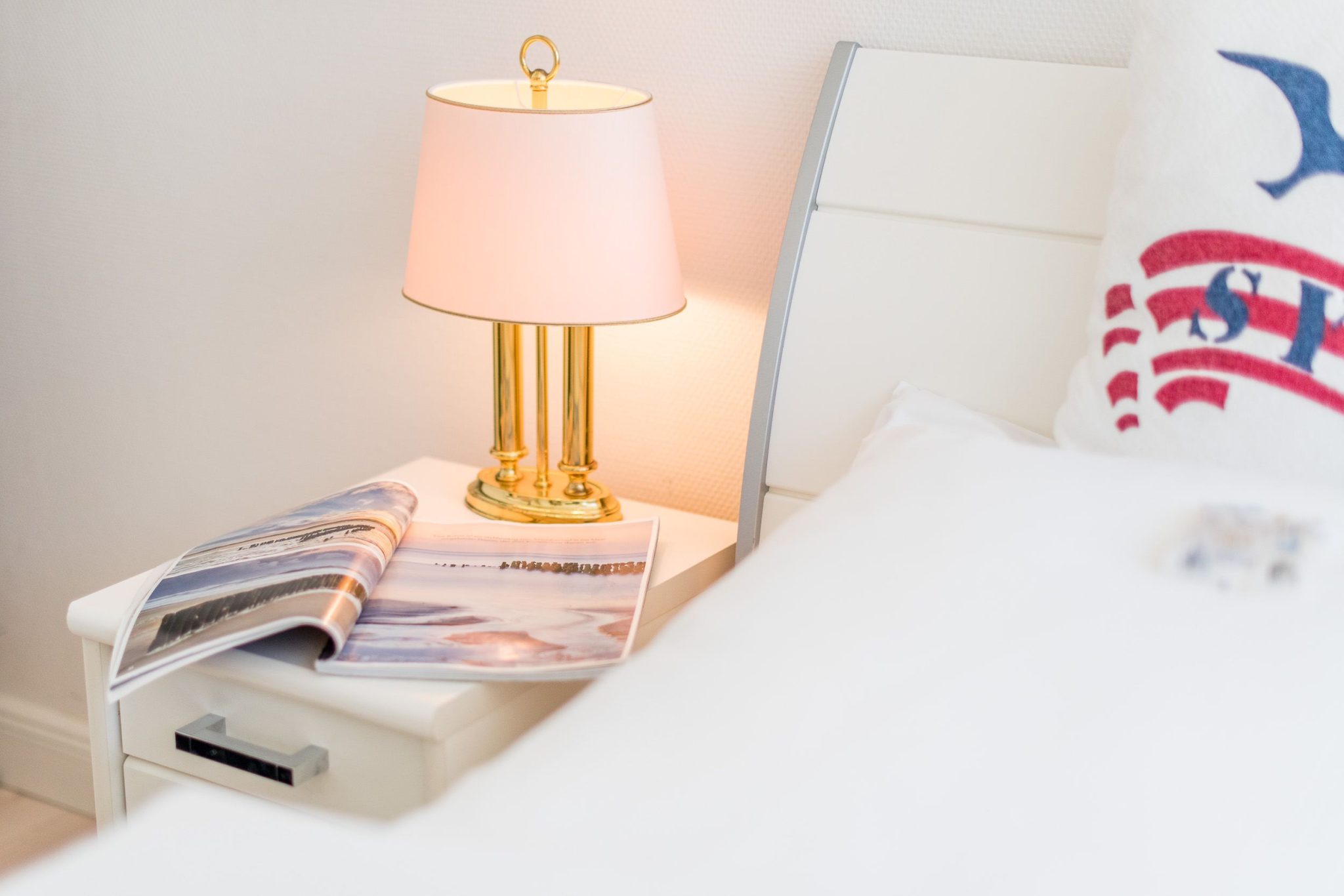 Bett in Schlafzimmer mit Nachttisch in Ferienhaus auf Sylt