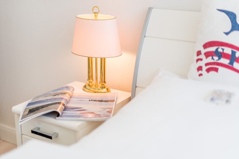 Bett in Schlafzimmer mit Nachttisch in Ferienhaus auf Sylt