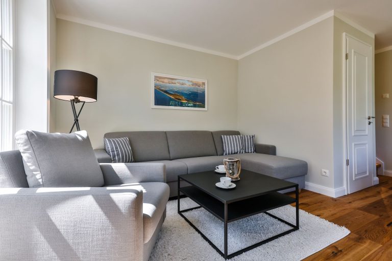 Wohnzimmer mit Sofa und Sessel in Ferienhaus auf Sylt