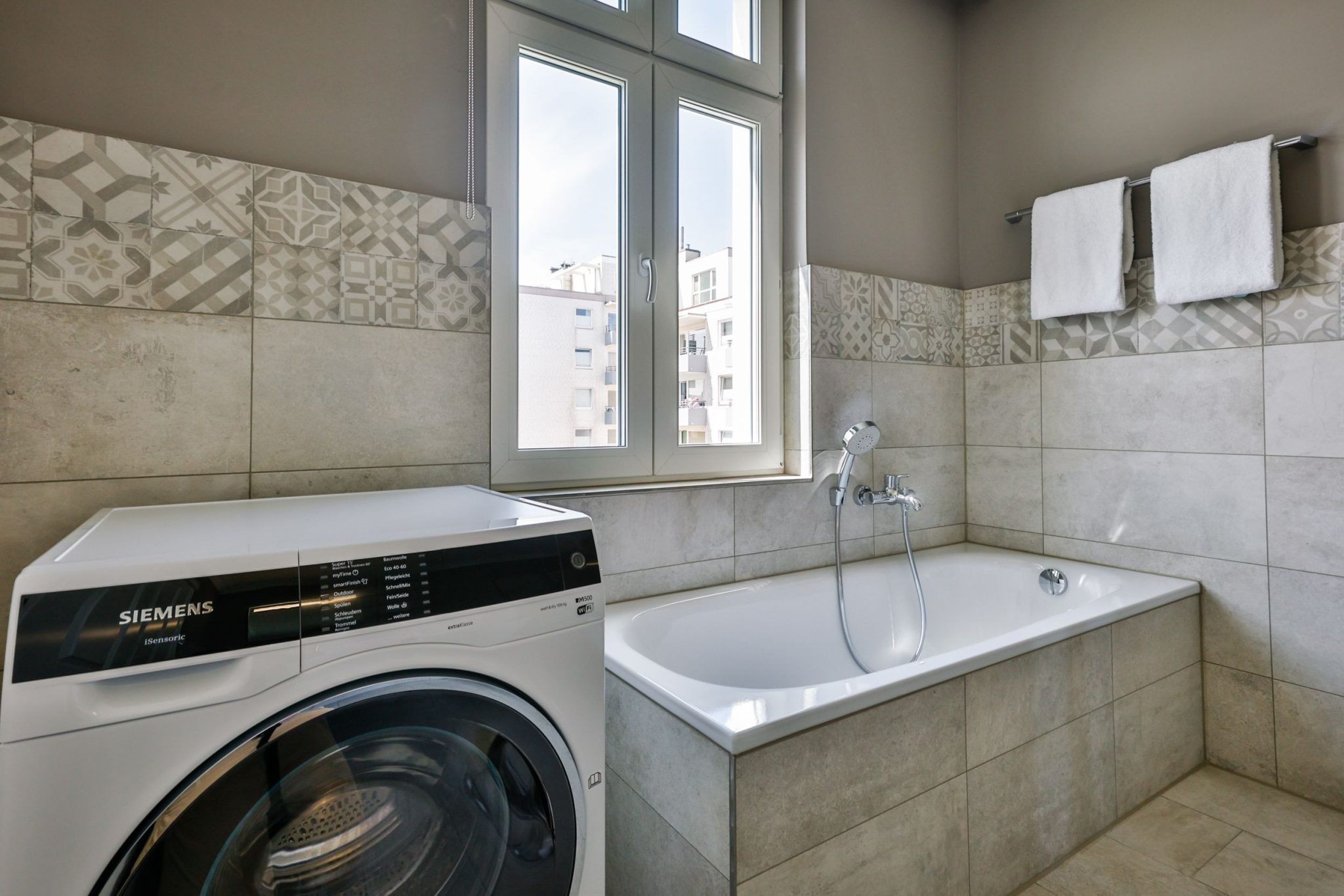 Badezimmer mit Badewanne und Waschmaschine in Ferienwohnung auf Sylt
