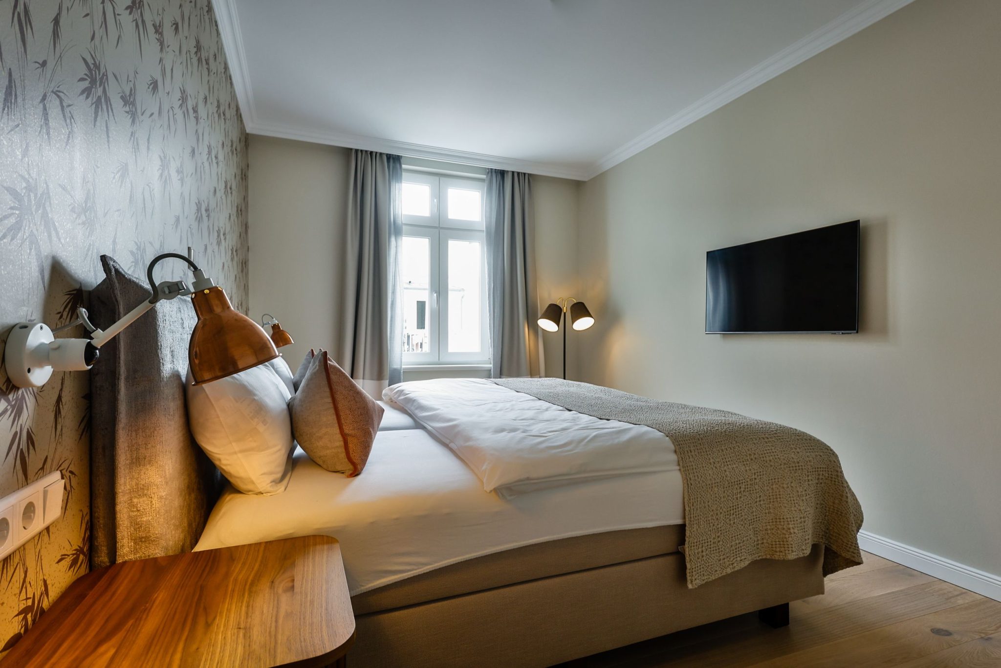 Schlafzimmer mit Fernseher und Doppelbett in Ferienwohnung auf Sylt