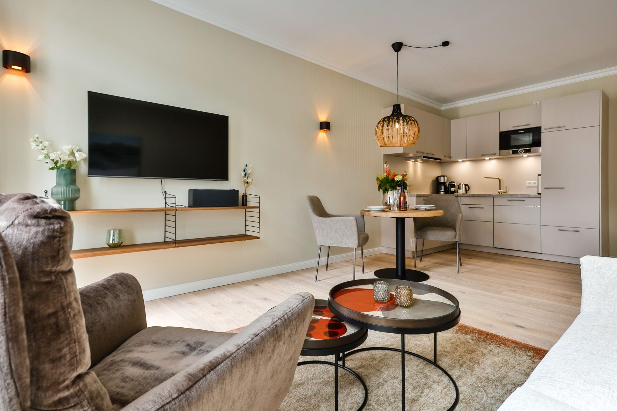 Wohnzimmer mit Küche und Fernseher in Ferienwohnung auf Sylt