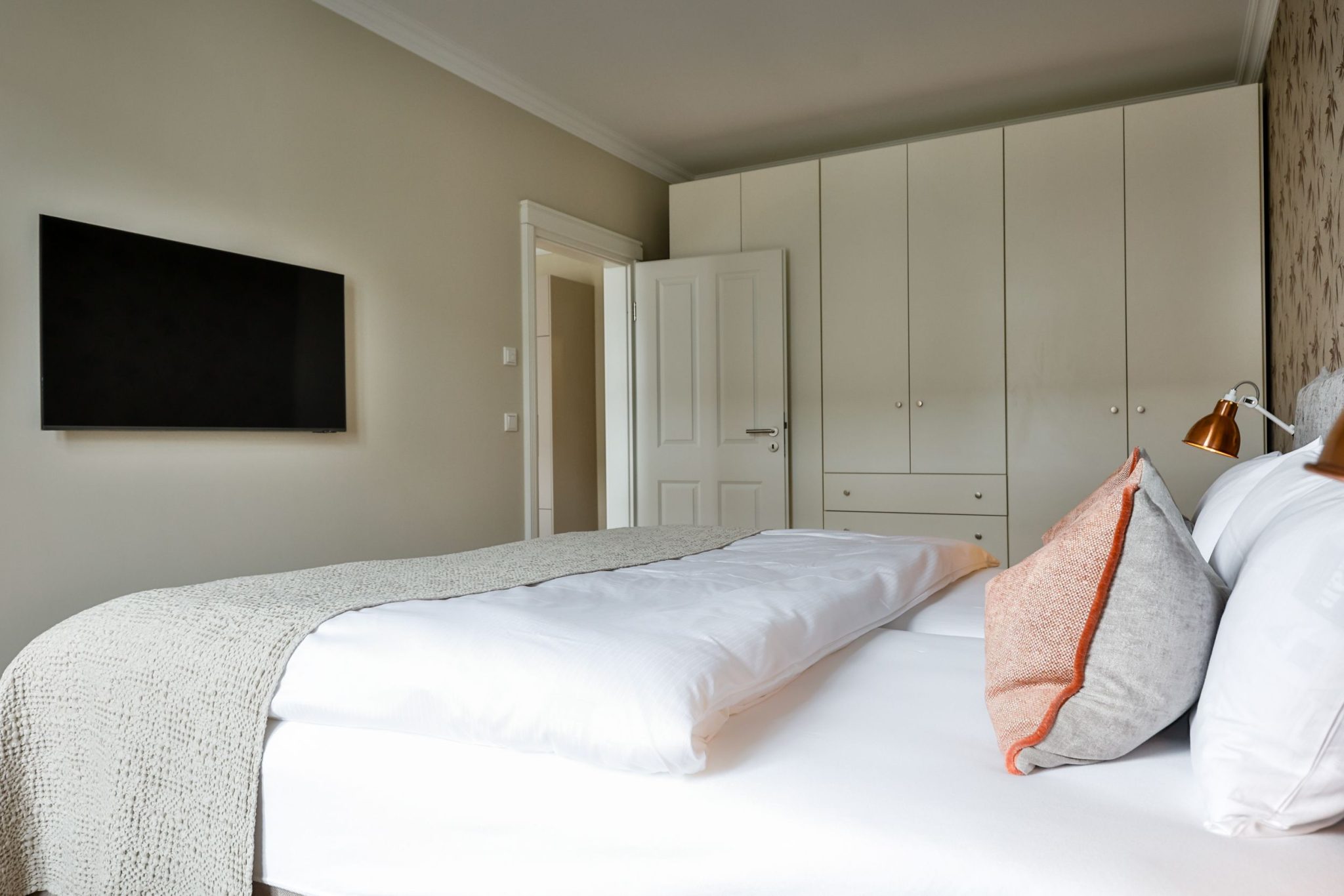 Schlafzimmer mit Doppelbett und Fernseher in Ferienwohnung auf Sylt