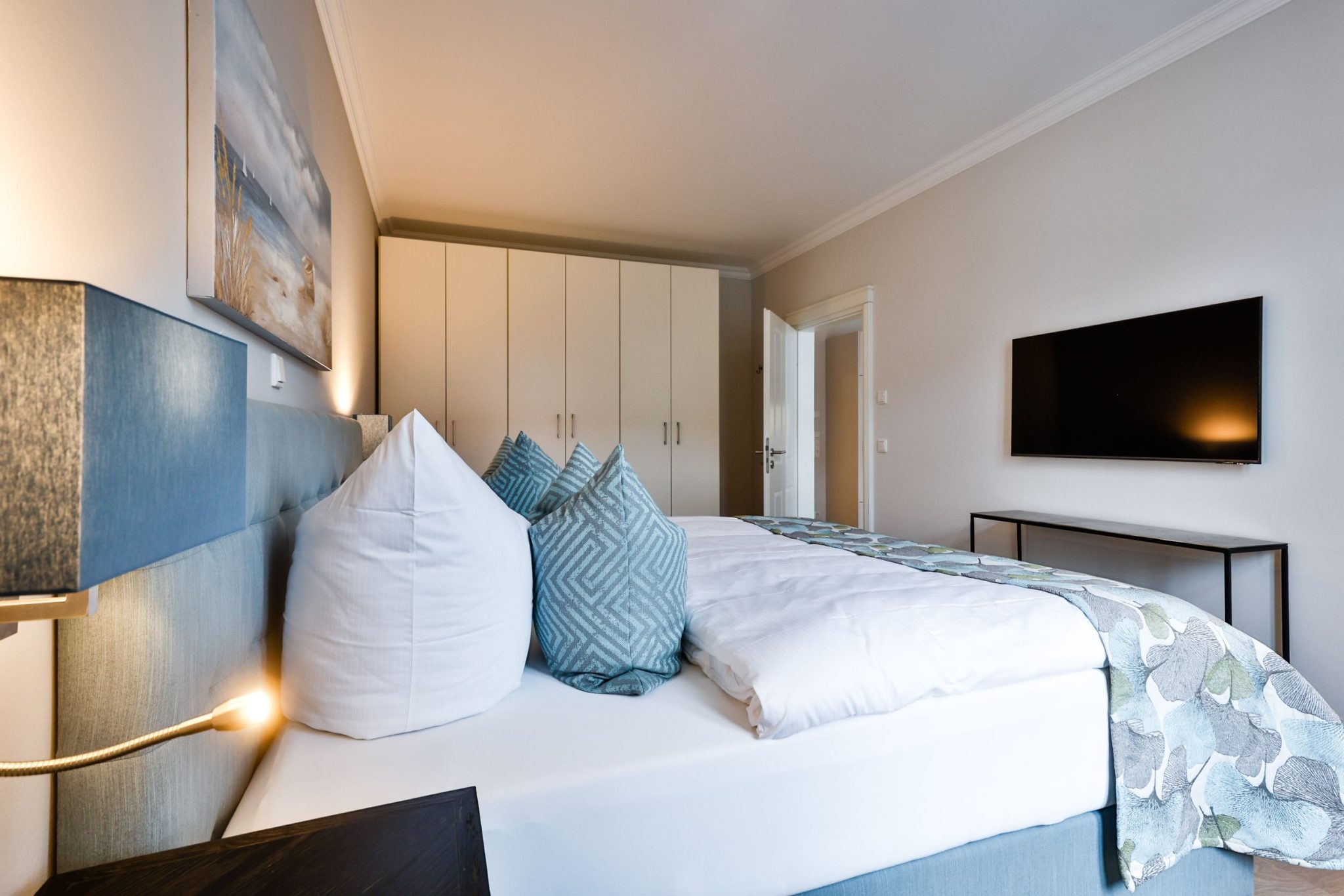 Schlafzimmer mit Doppelbett und Fernseher in Ferienwohnung auf Sylt