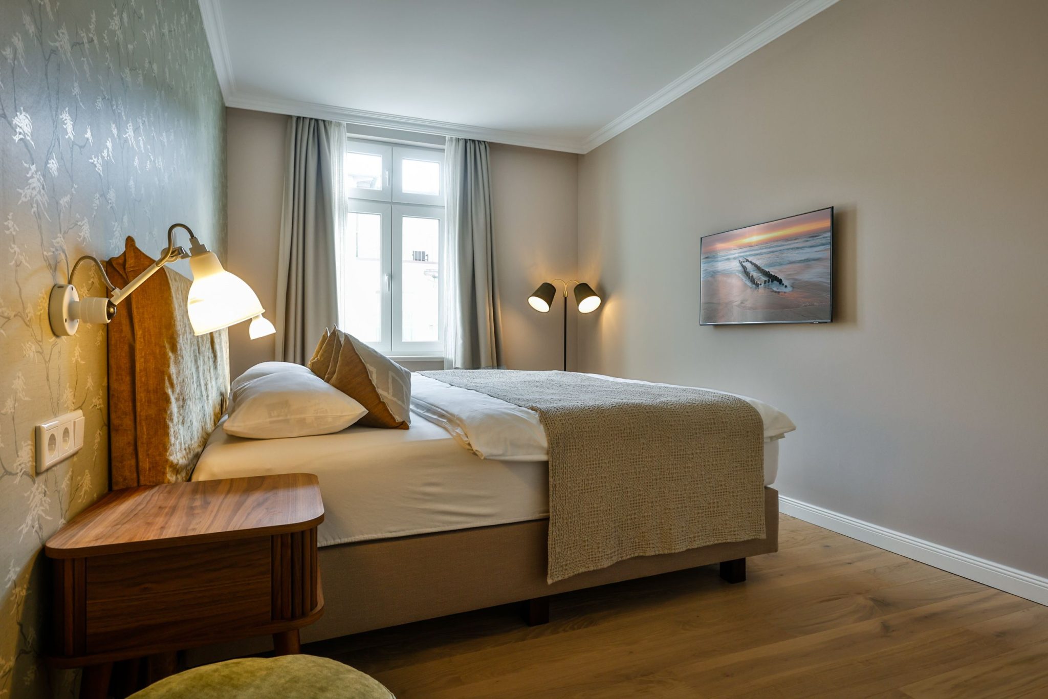 Schlafzimmer mit Doppelbett und Fernseher in Ferienwohnung auf Sylt