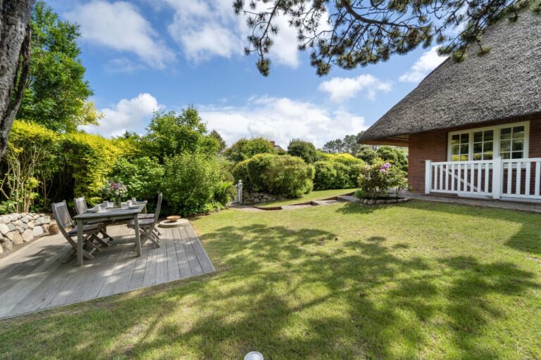 großer Garten mit Gartenmöbeln vor einem Ferienhaus auf Sylt
