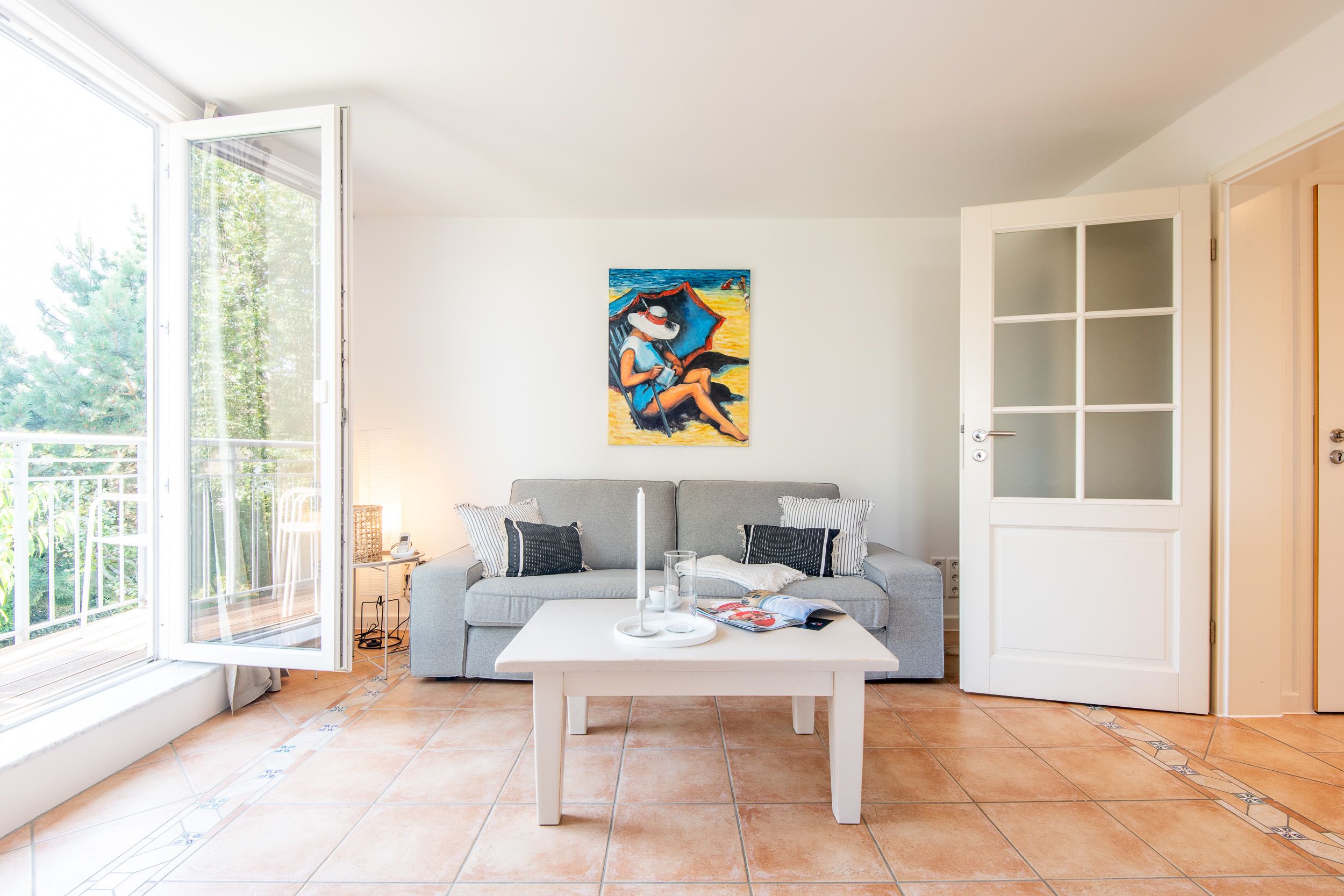Sofa mit einem kleinem Tisch und einem Bild an der Wand in einem Ferienhaus auf Sylt