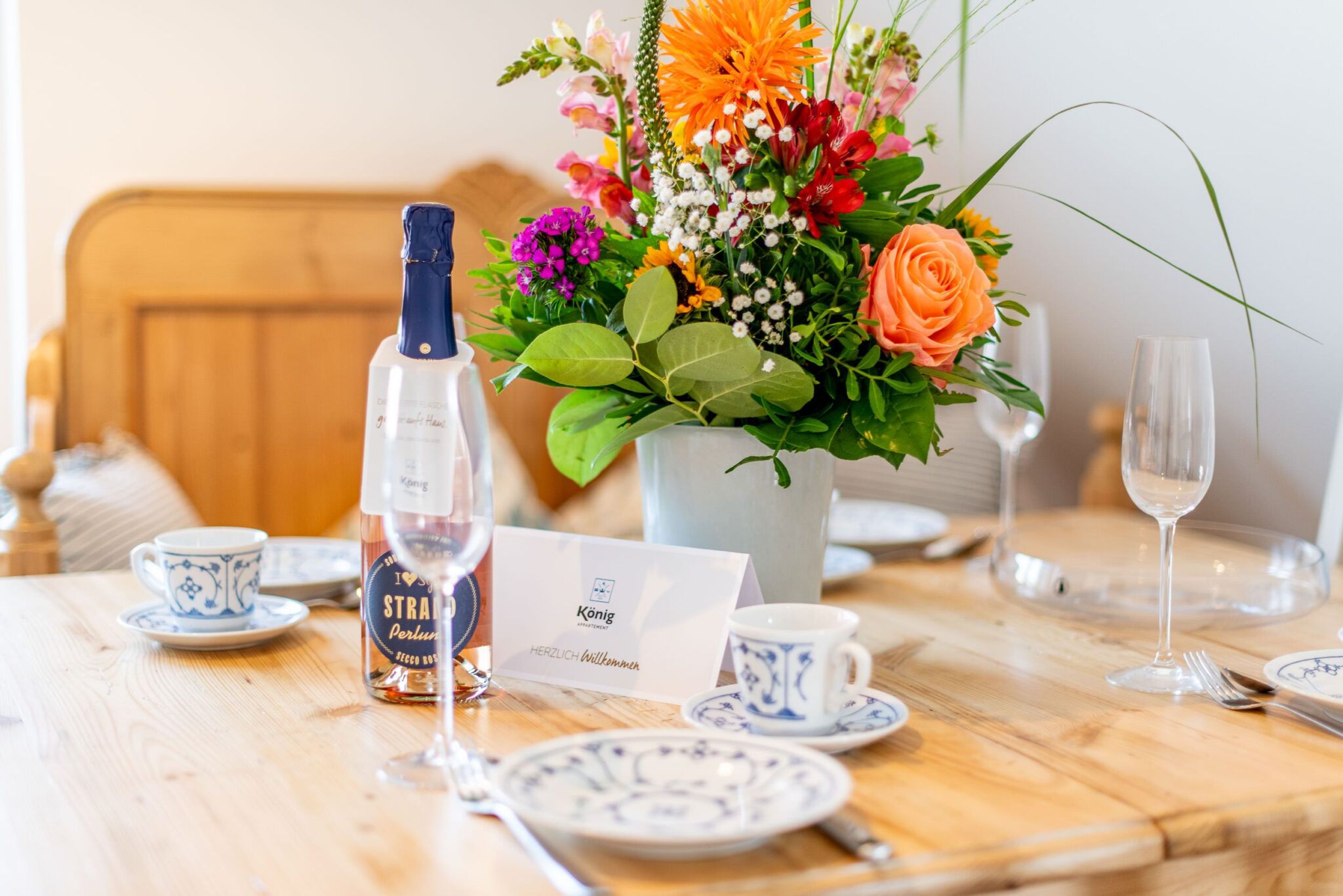 gedeckter Tisch mit Blumen in einem Ferienhaus auf Sylt