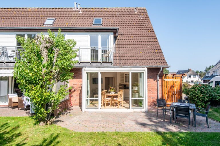 Außenansicht von einem Ferienhaus auf Sylt mit Wintergarten und Terrasse